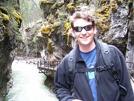Image of Dr. Joe Casola smiling wile posing near a rushing river.